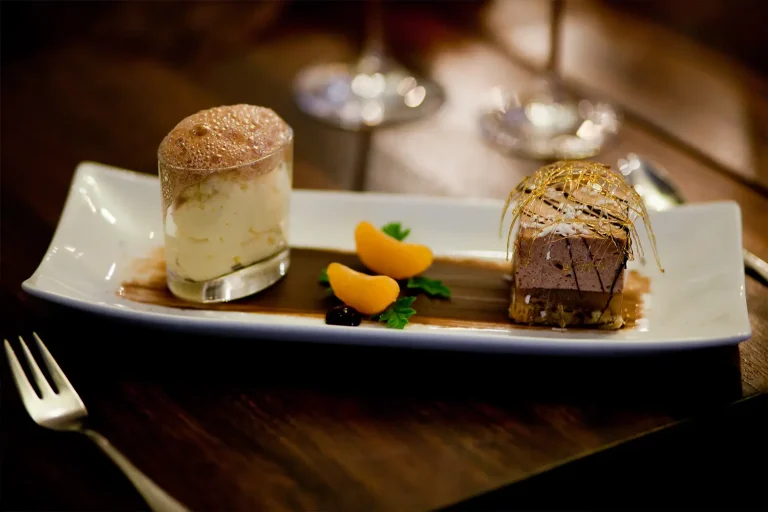Teller mit Dessert Glas, Mandarinenscheiben und einer Mousse, kunstvoll angerichtet