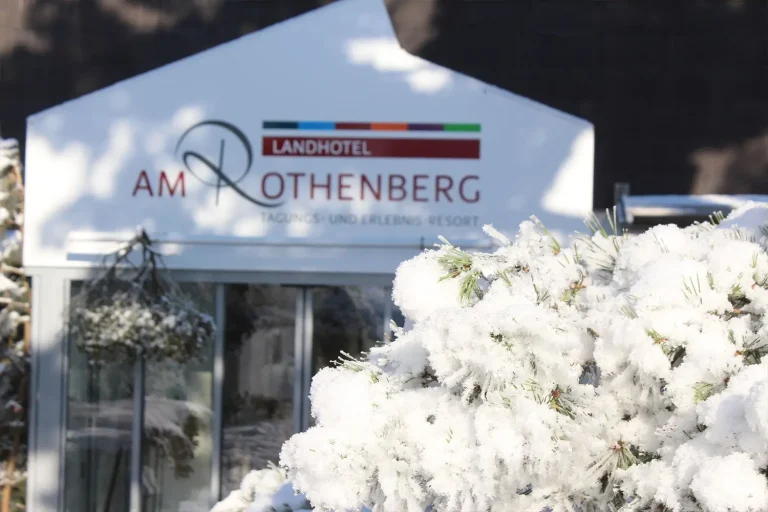 Hoteleingang mit schneebedecktem Busch