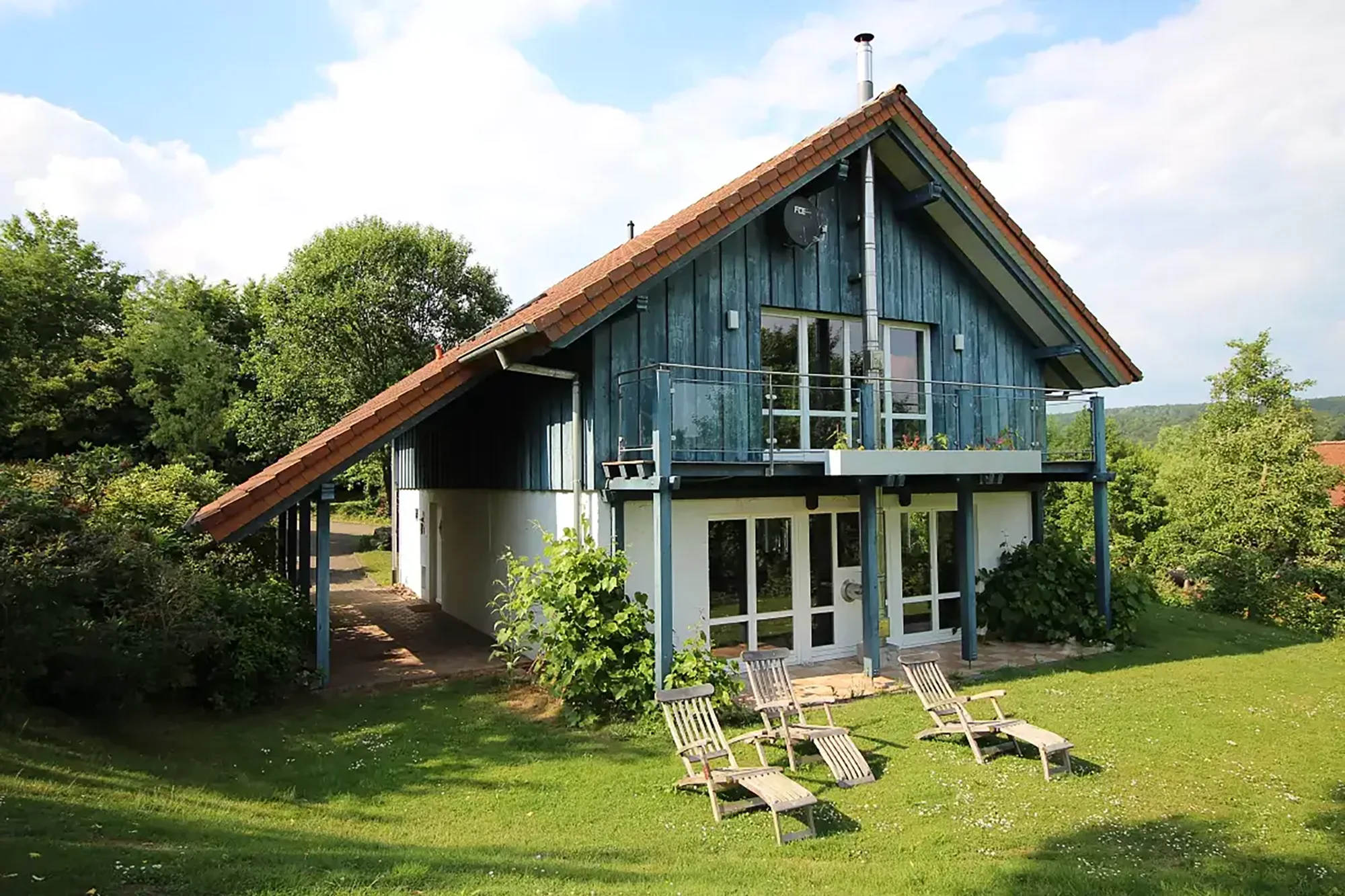 Ein zweistöckiges Ferienhaus im Landhaus-Stil mitten im Grünen.