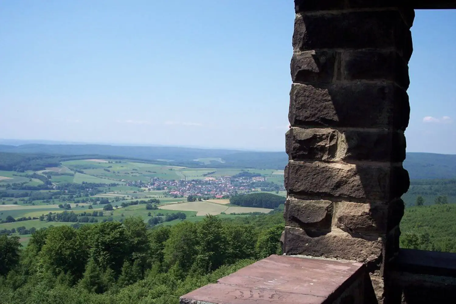 Blick von einem Aussichtsturm auf eine grüne Landschaft