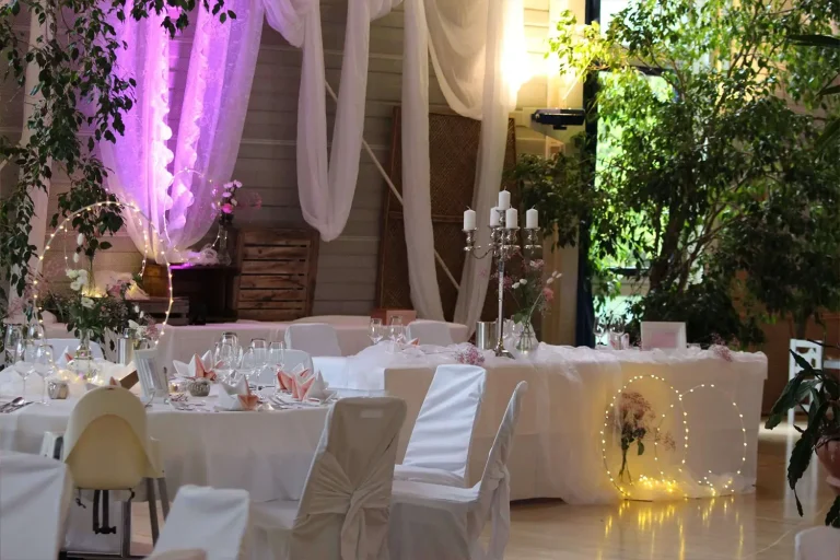 Festlich weiß geschmückte Tische, stimmungsvolles Licht und Stoffbahnen, die von der Decke hängen