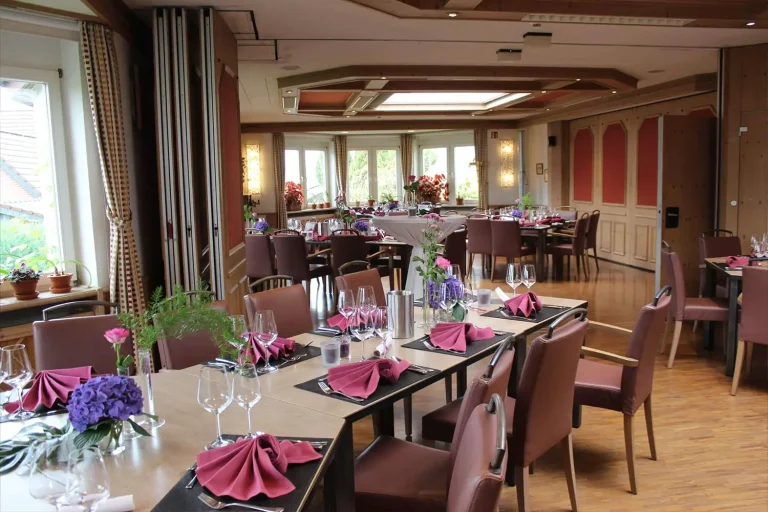 Drei festlich geschmückte Tafeln in einem rustikalen Saal