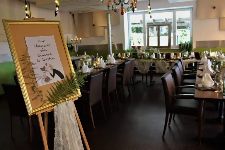 Eine Festtafel in U-Form aufgestellt, festlich geschmückt für eine Hochzeit