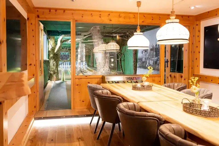 Vorraum einer Kegelbahn mit rustikalem Holztisch und gemütlichen Sesseln