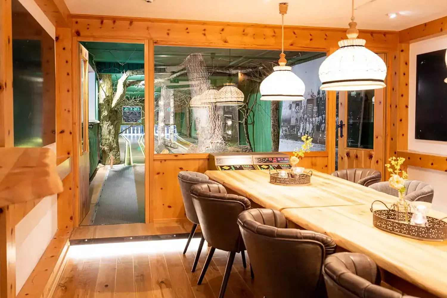 Vorraum einer Kegelbahn mit rustikalem Holztisch und gemütlichen Sesseln