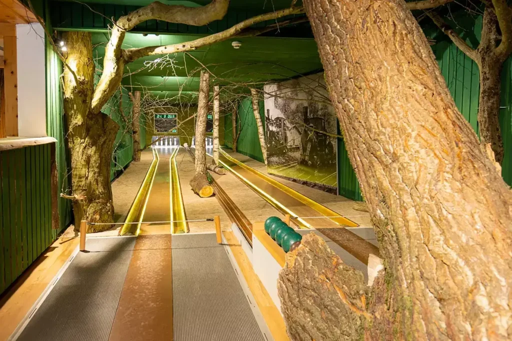 Eine Kegelbahn mit zwei Scherenbahnen, dekoriert mit Holzstämmen