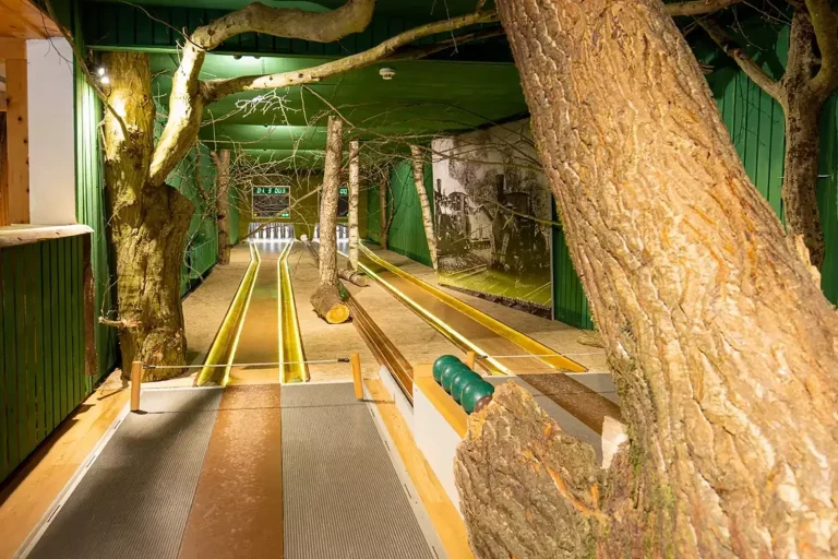 Eine Kegelbahn mit zwei Scherenbahnen, dekoriert mit Holzstämmen