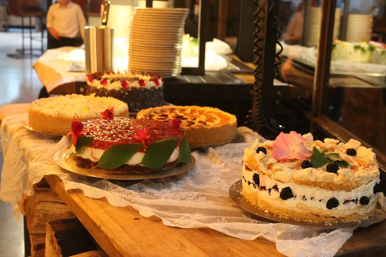 Kuchenbuffet mit einer Auswahl an Kuchen und Torten, kunstvoll verziert mit Blüten