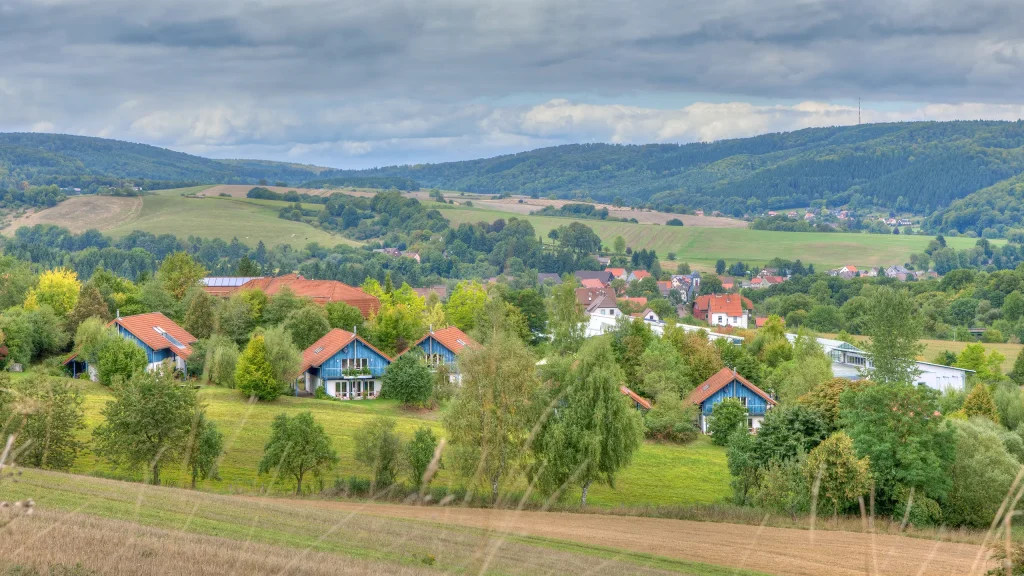 Landschaftsbild mit vielen Feldern, Wald und Ferienhäusern