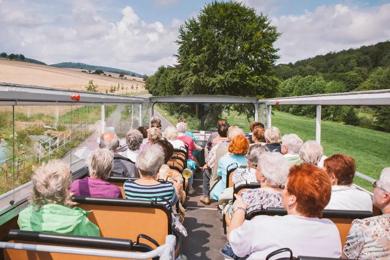 Eine Reisegruppe, die mit einem Cabrio-Bus durch die Landschaft fährt