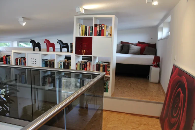 Eine Galerie mit niedriger Decke, Schlafgelegenheiten und Regalen