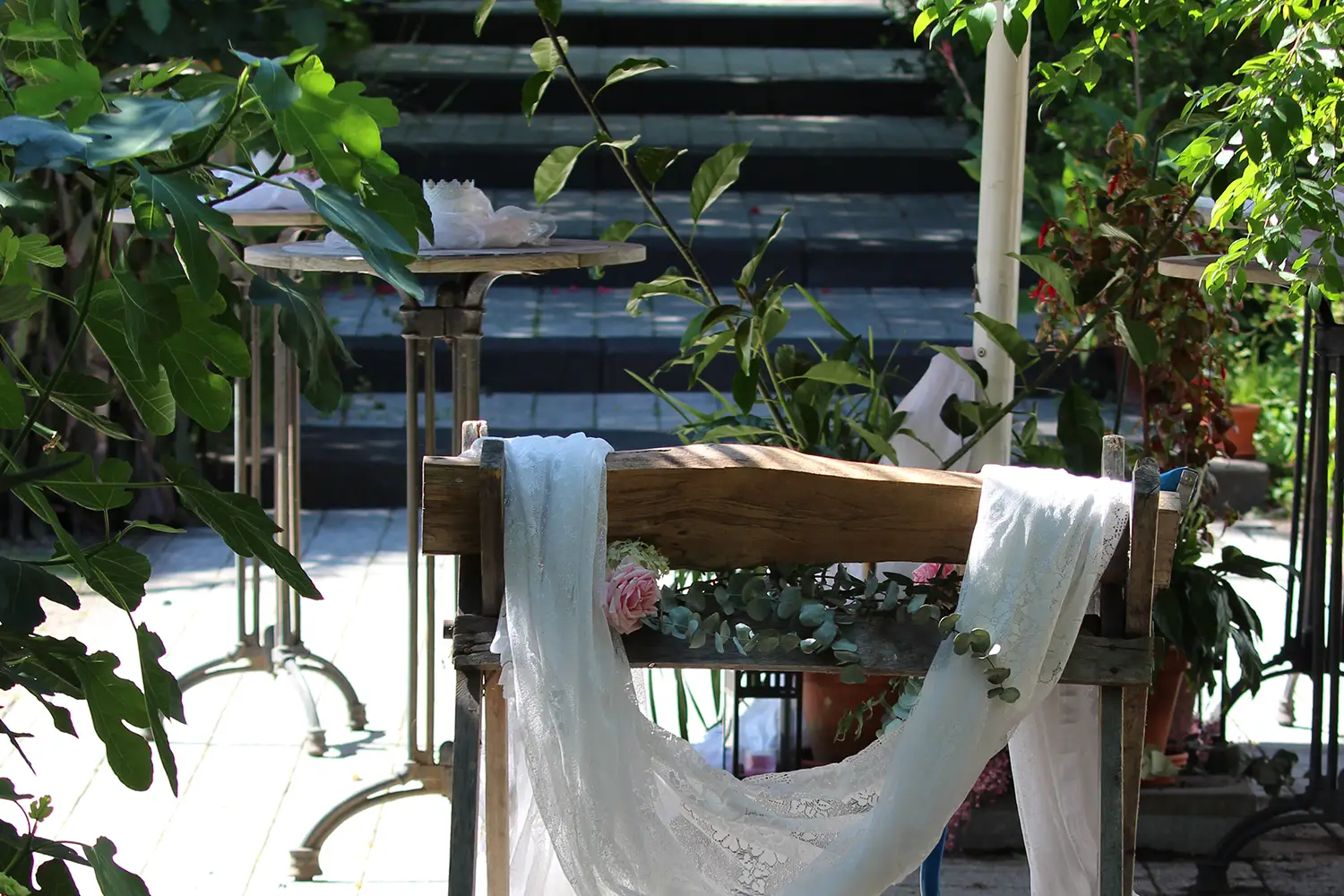 Ein Sägebock mit einem Holzscheit, der mit Blüten und einem weißen Tuch für eine Hochzeit dekoriert ist