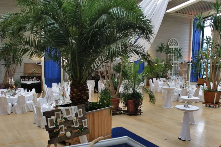 Festlich geschmückte in einer großen Halle mit Holzfußboden und Palmen