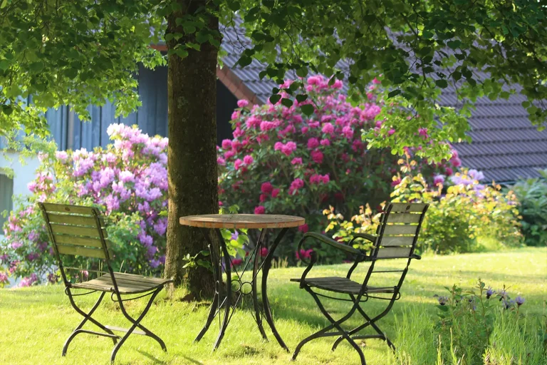 Zwei Gartenstühle und ein Gartentisch auf einem idyllischen Platz im Grünen