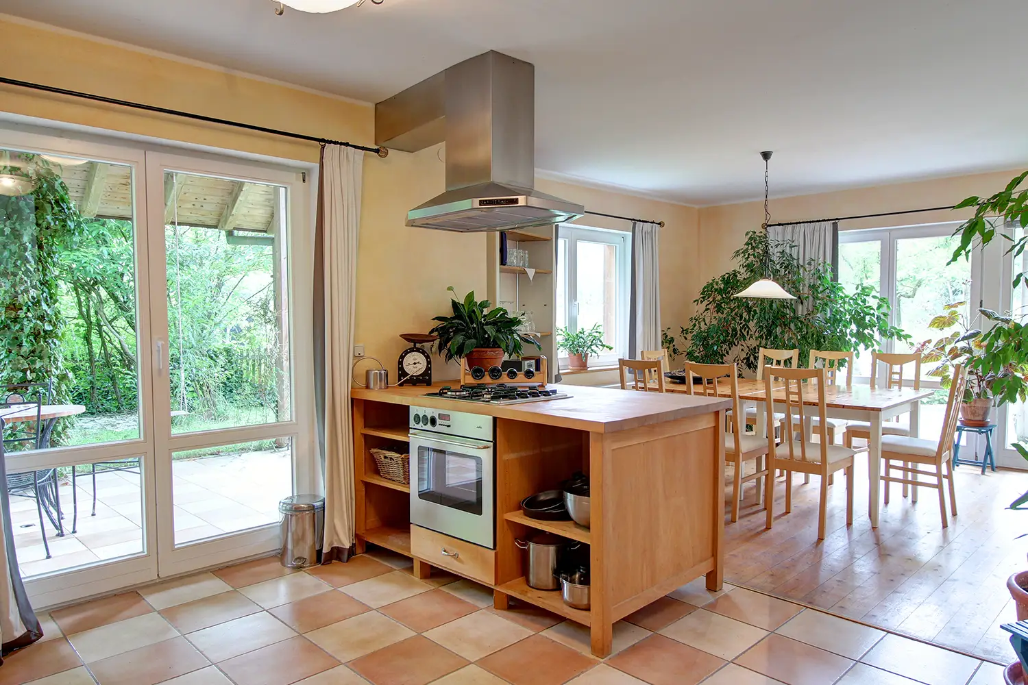 Wohnküche mit Gasherd und Essbereich für acht Personen in einem großen Raum mit vielen Fenstern