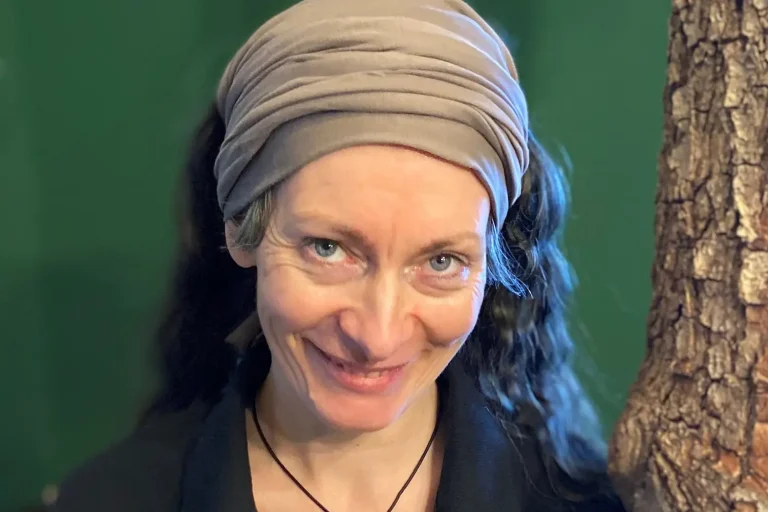 Eine dunkelhaarige Frau vor einer grünen Wand