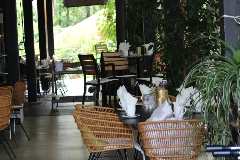 Überdachte Sitzgruppen im Freien, die für eine Kaffeetafel gedeckt sind