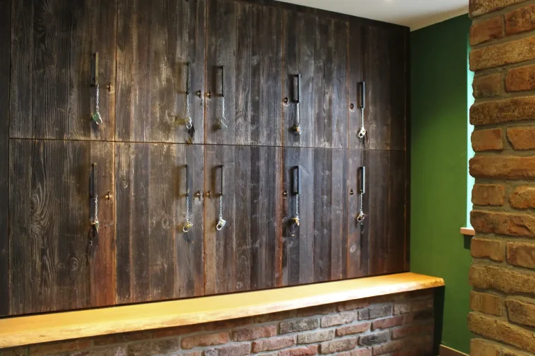 Eine Schrankwand aus dunklem Holz mit vielen einzeln abschließbaren Schrankfächern