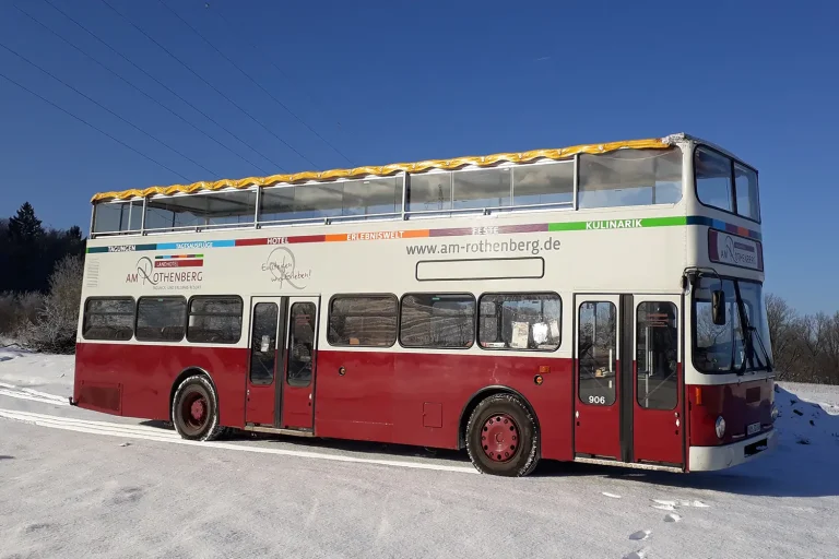 Ein Doppeldecker-Bus auf einer zugeschneiten Wiese