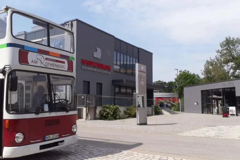 Ein Oldtimer-Bus auf einem Parkplatz vor einem Museum
