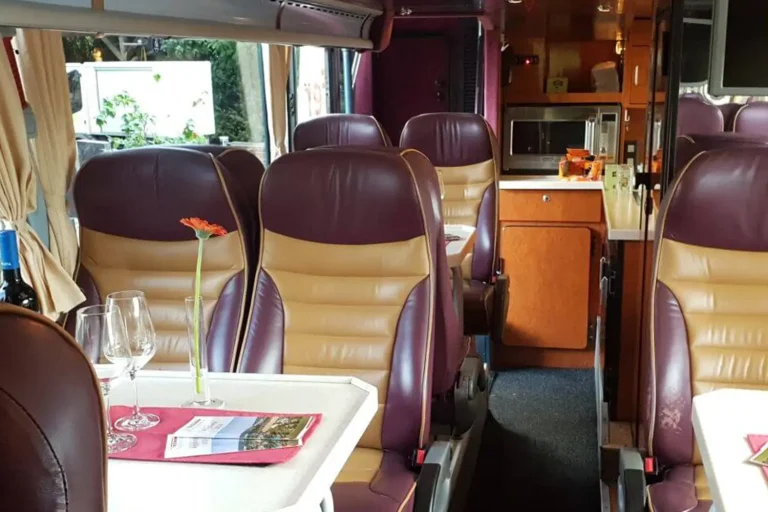 Innenraum eines Reisebusses mit gepolsterten Ledersitzen und Bord-Bar