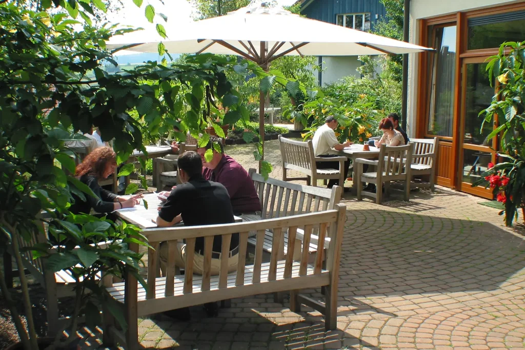 Kleine Menschengruppen sitzen im Freien und arbeiten konzentriert